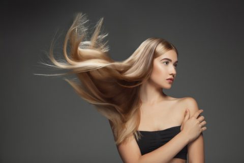 Beautiful model with long smooth flying blonde hair isolated dark grey studio background young caucasian model with well kept skin hair blowing air 155003 21880